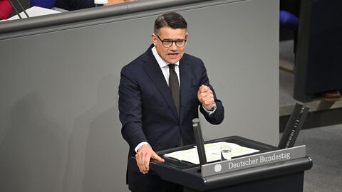 Ministerpräsident Rhein steht am Rednerpult des Bundestags und hält seine Rede.