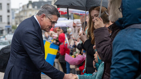 Ministerpräsident Rhein schüttelt einem kleinem Mädchen die Hand.